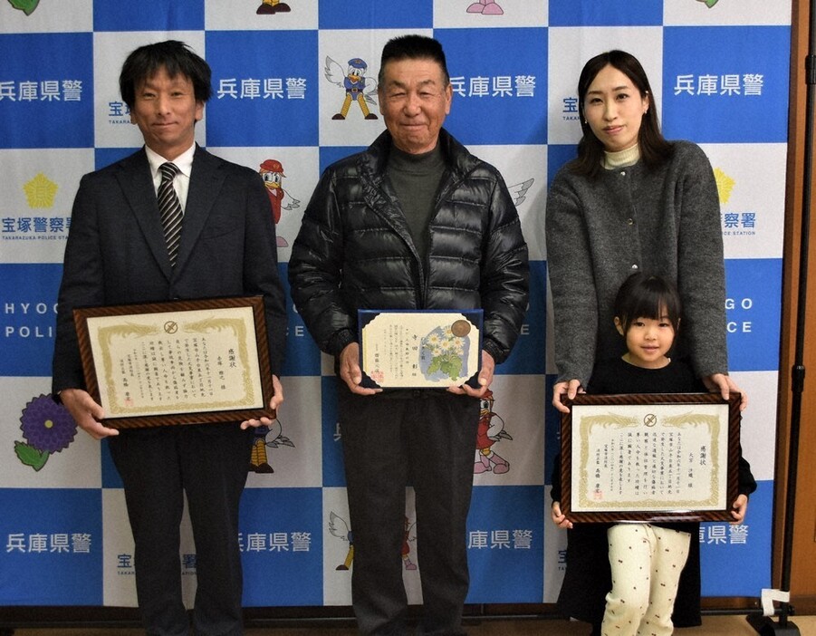 のじぎく賞と宝塚市消防本部の感謝状を贈られた（左から）赤塚雅之さん、寺田彰さん、大宮沙織さん。大宮さんの前は長女の奈々さん。事故当時も一緒で母たちの活躍を見ていた＝兵庫県警宝塚署で２０２４年１２月１７日午前１１時１３分、土居和弘撮影