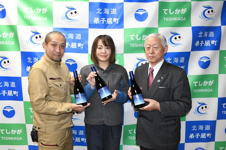 新作のテシカを手に徳永町長と木龍さん、上村社長（右から）＝弟子屈町役場提供