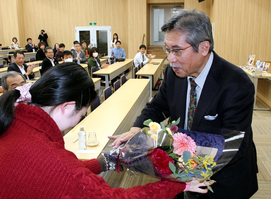 最終講義を終え、花束を受け取る弘兼さん（右）