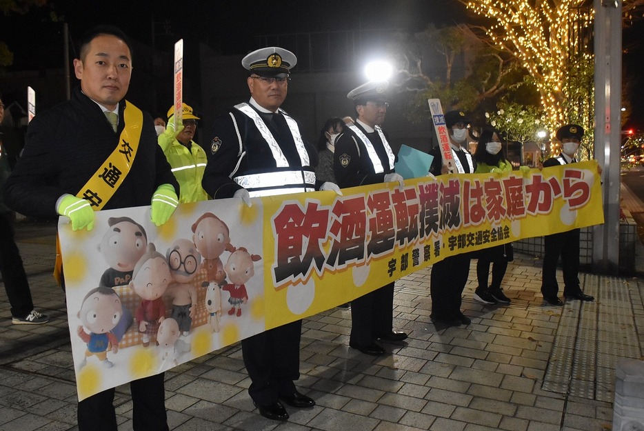 横断幕を掲げて飲酒運転撲滅を呼び掛ける参加者（JR宇部新川駅近くで）