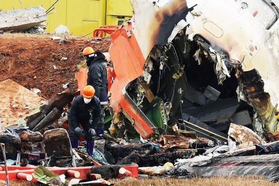 ３０日、全羅南道務安（ムアン）国際空港のチェジュ航空旅客機事故現場で関係者らが捜索作業を行っている。　チャン・ジンヨン記者