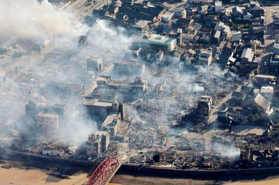 能登半島地震による火災が発生し、煙が上がる石川県輪島市の市街地＝2024年1月2日（時事）