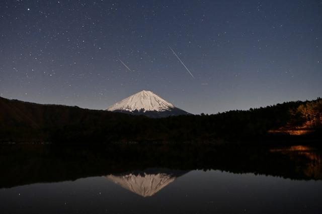 逆さ富士とふたご座流星群=2021年12月13日午後10時12分と午後11時に撮影した2枚を比較明合成、山梨県富士河口湖町、福留庸友撮影