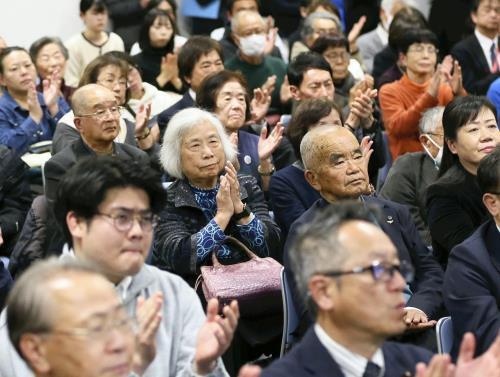 田中煕巳さんの演説を聞き、握手を送る関係者ら（１０日午後９時５７分、長崎市役所で）＝田中勝美撮影