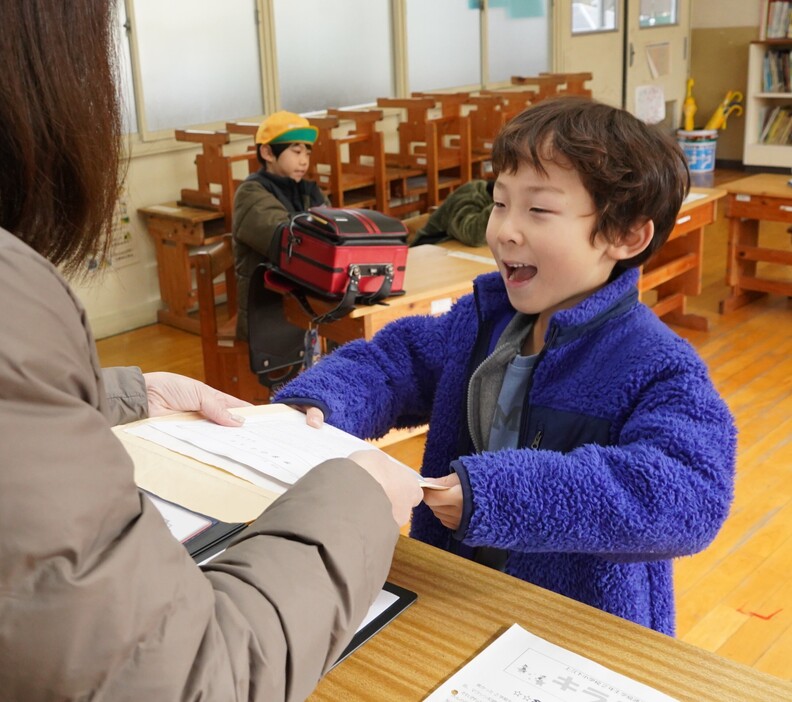 担任から通知表を受け取る児童＝2024年12月25日午前9時20分、兵庫県丹波市山南町青田で