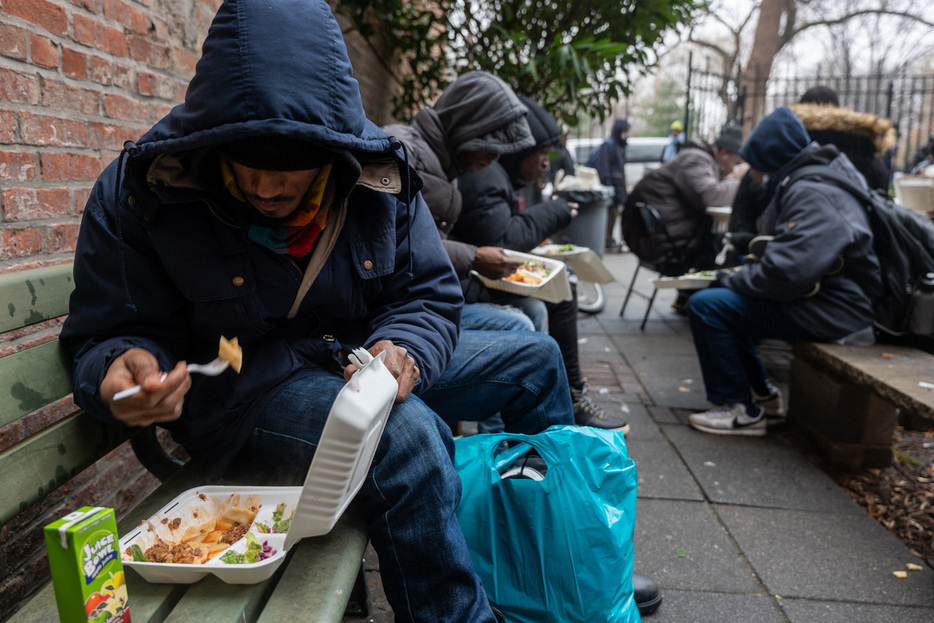 １月、米ニューヨークの教会が配った食事をとるホームレス（ＡＦＰ時事）