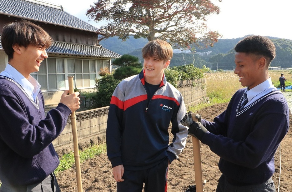 畑での作業中に友人と談笑するサマルハさん（中央）＝佐世保市内