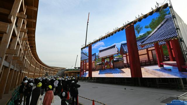 報道公開された韓国パビリオンの巨大モニター。左は木造の「大屋根リング」=2024年12月20日午後2時23分、大阪・夢洲、白井伸洋撮影