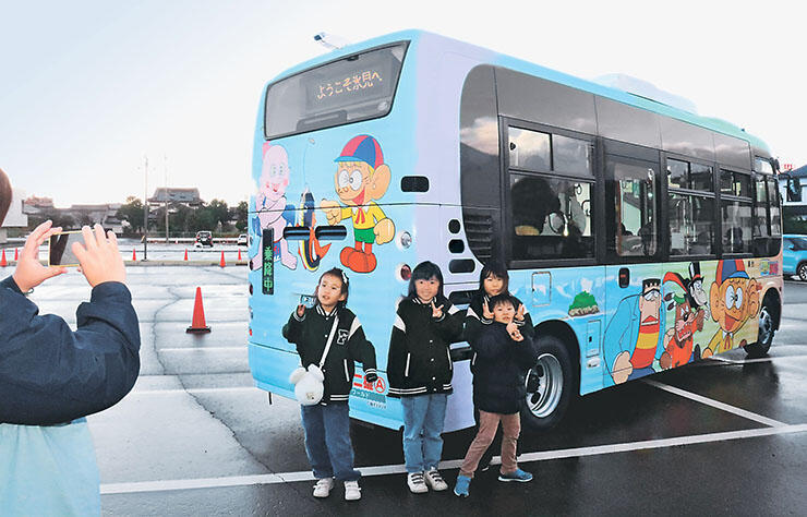 新しいデザインの車両と写真を撮る子どもたち