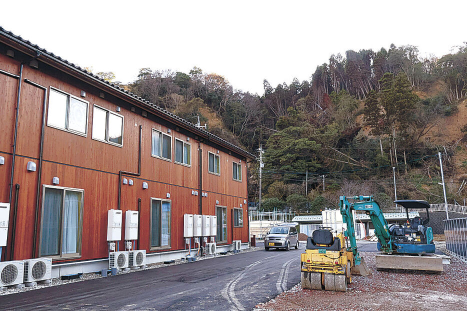 整備が続く「大谷町第１団地」。裏山には土砂崩れの痕が生々しく残る＝珠洲市大谷町