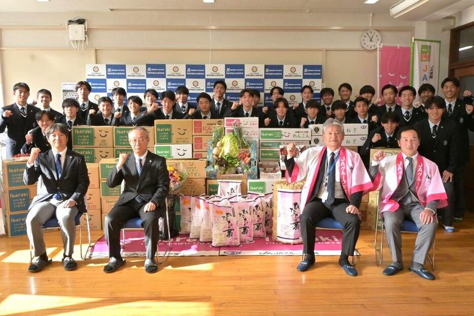 寄贈された県産食材を前に活躍を誓った明秀日立高サッカー部のメンバーら=日立市神峰町