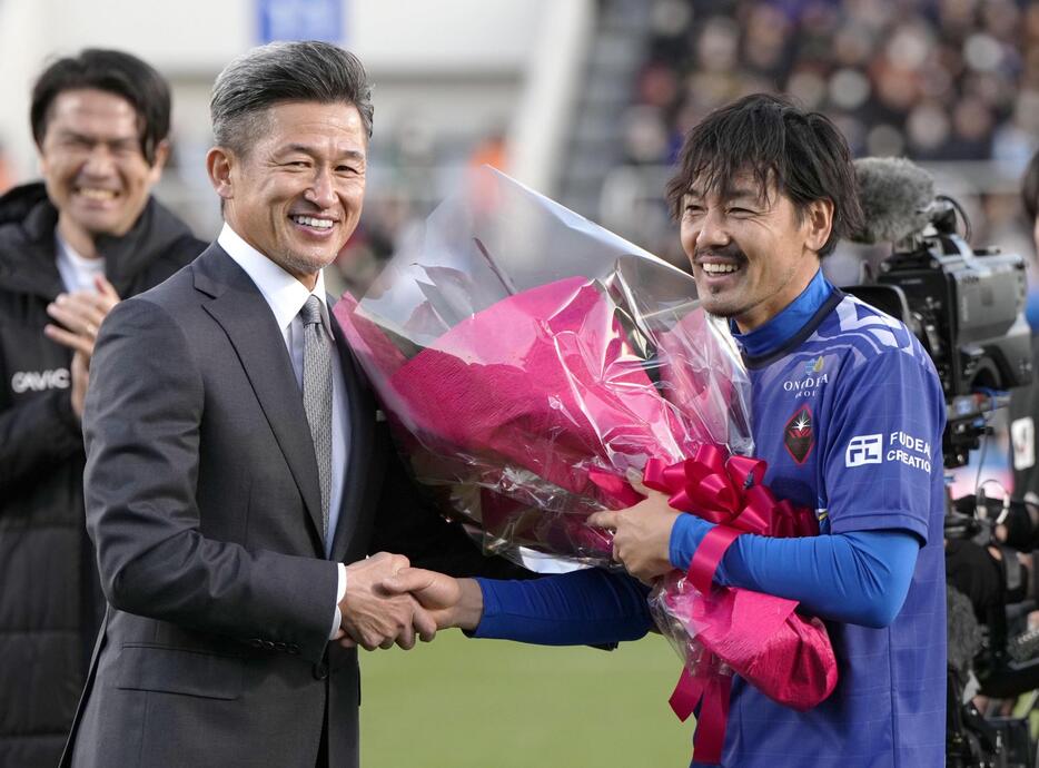 引退試合を終え、鈴鹿・三浦から花束を贈られる松井大輔さん（右）＝ニッパツ