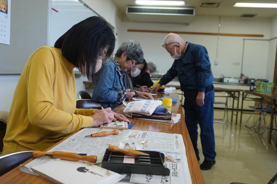 年賀状の木版画作りを楽しむ参加者=岡山県津山市で