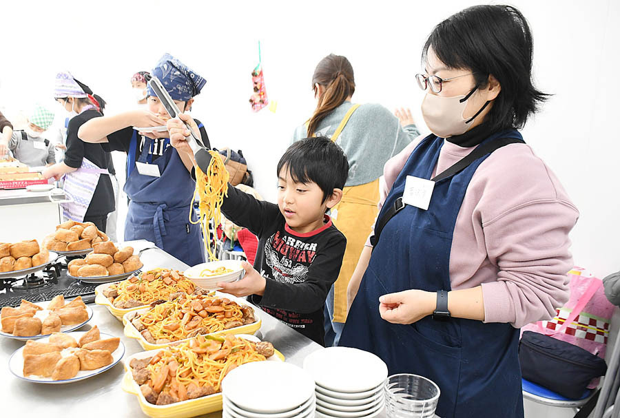 自分たちで作った料理を器に盛る子どもら