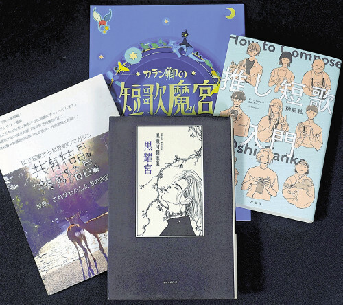 黒瀬さんの第１歌集「黒耀宮」（ながらみ書房、２００２年）（中央下）。左はＢＬ短歌同人誌「共有結晶」（２０１２年）、右は榊原紘さんの「推し短歌入門」。バックは同人誌版「短歌魔宮」