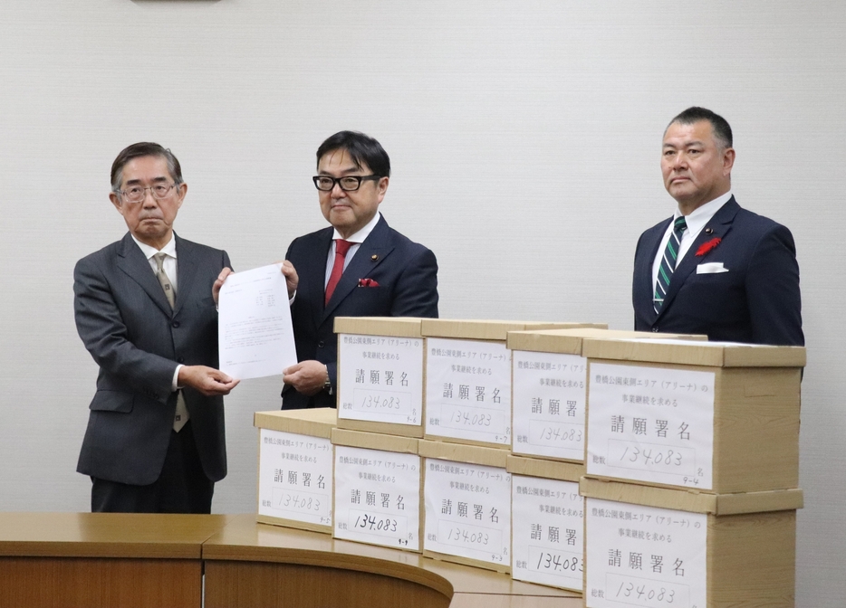 伊藤議長（中央）に請願書と署名簿を提出する川西共同代表㊧＝豊橋市役所で