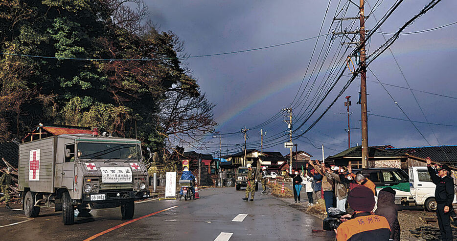 車列を見送る住民＝１７日午前１０時２８分、珠洲市大谷町