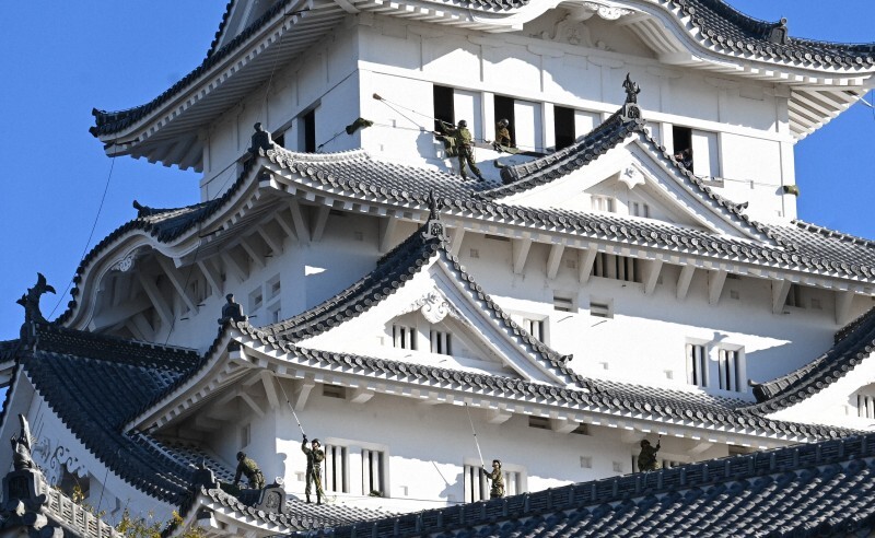 姫路城大天守の屋根ですす払いする陸上自衛隊のレンジャー隊員ら＝兵庫県姫路市本町で2024年12月19日午前8時57分、村元展也撮影