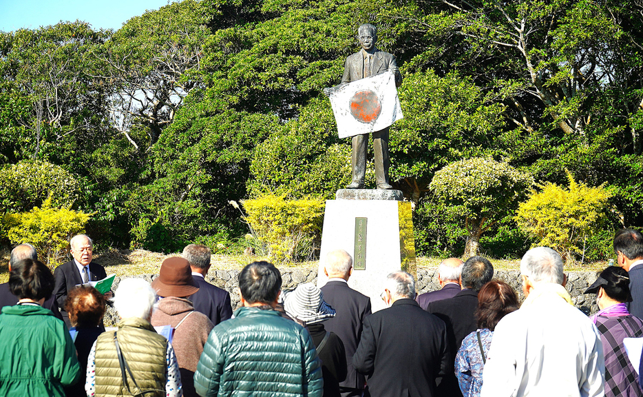 出身地伊仙町の泉芳朗頌徳記念碑像前であった「徳之島　群島民のつどい」＝25日、同町義名山公園