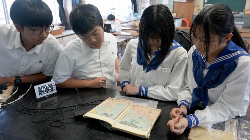 松田日菜子さんから送られてきた江戸時代の文献を見る生徒ら＝宇土高科学部提供