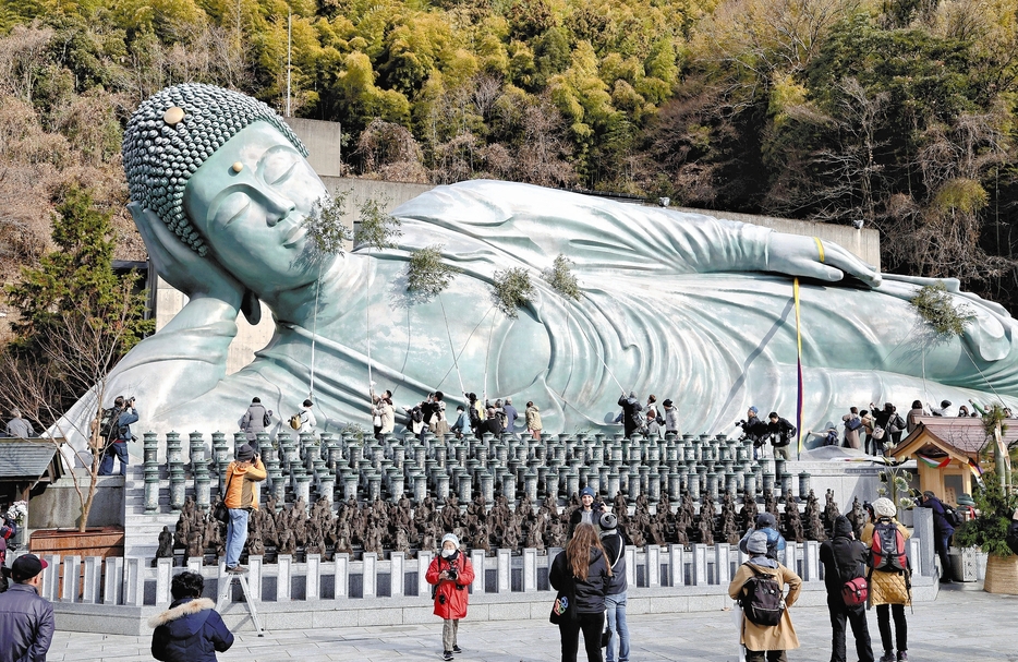 ササ竹ですすを払い落とされる釈迦涅槃像（26日午前、福岡県篠栗町の南蔵院で）＝秋月正樹撮影