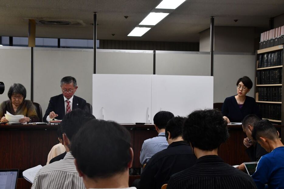 判決後の記者会見。登壇した原告2人の席の前には白い衝立が置かれた。（撮影／小川たまか）