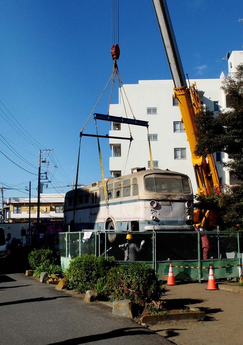 クレーンにつり上げられ、搬出されるトロリーバス「１０４号」＝２１日、川崎市高津区