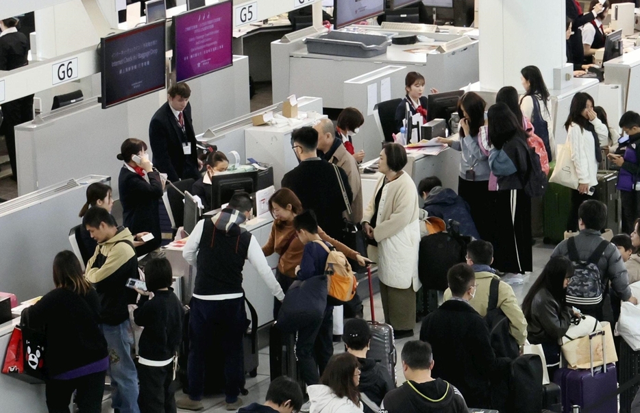 航空会社のカウンター付近で列を作る人たち（28日午後、福岡市博多区の福岡空港国際線ターミナルで）＝秋月正樹撮影