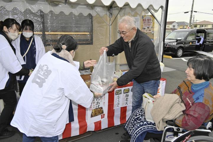 年越しそばを買い求める来店客（右）＝30日午後、松山市南久米町