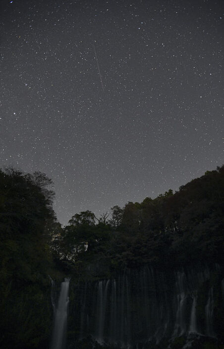 白糸の滝の上空で光跡を描く「ふたご座流星群」＝12日午前3時7分、富士宮市上井出（写真部・宮崎隆男）