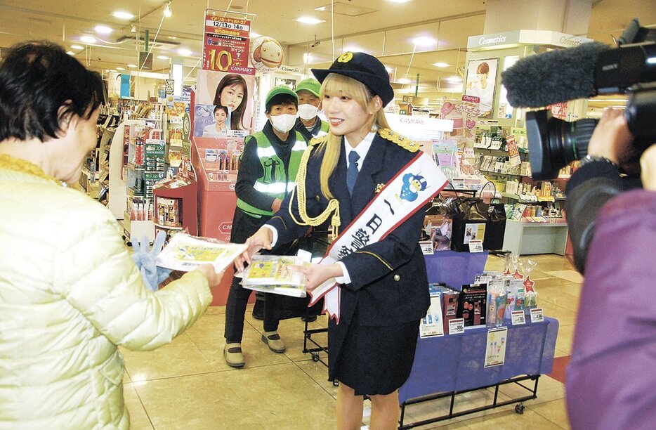 来店客に啓発グッズを配る森下さん