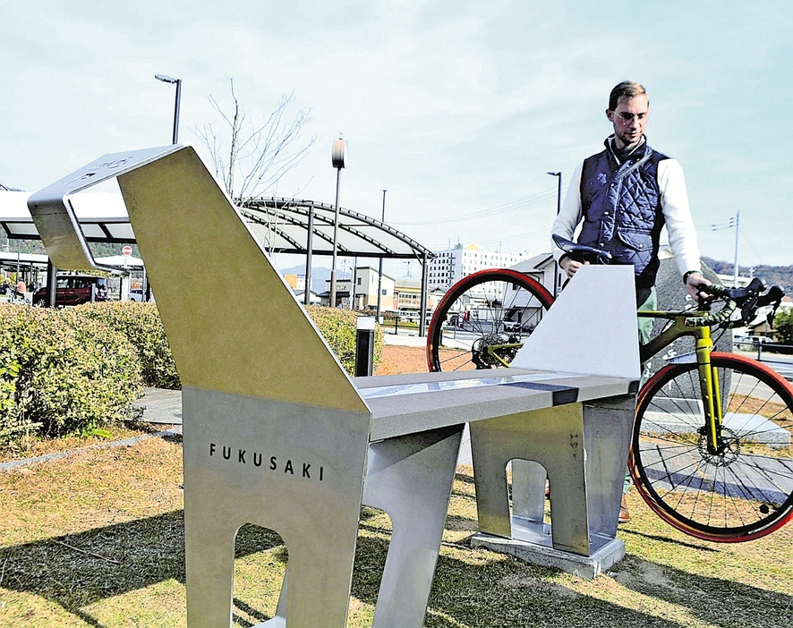 ベンチの形をしたアート作品とネルさん（兵庫県福崎町のJR福崎駅前で）