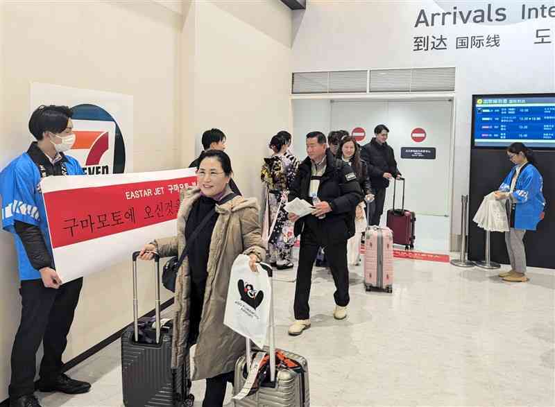 イースター航空の第1便で韓国・釜山から熊本空港に到着した観光客ら＝19日、益城町