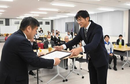 井田建社長（左）から感謝状を受け取る南里研二さん＝佐賀市高木瀬西のミゾタ製造本部