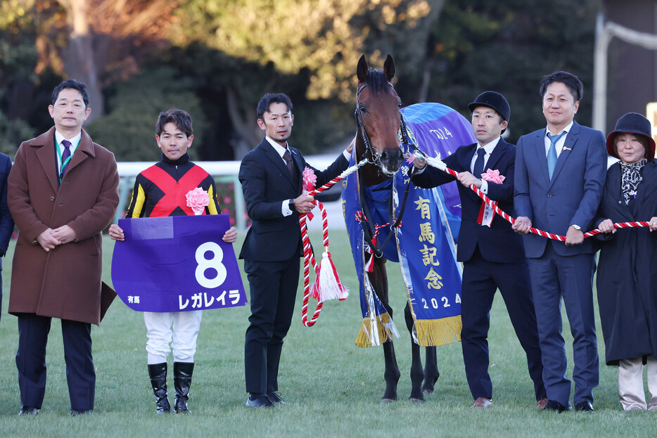 第６９回有馬記念を制し、写真に納まる戸崎圭太騎手（左から２人目）とレガレイラ＝２２日、中山競馬場