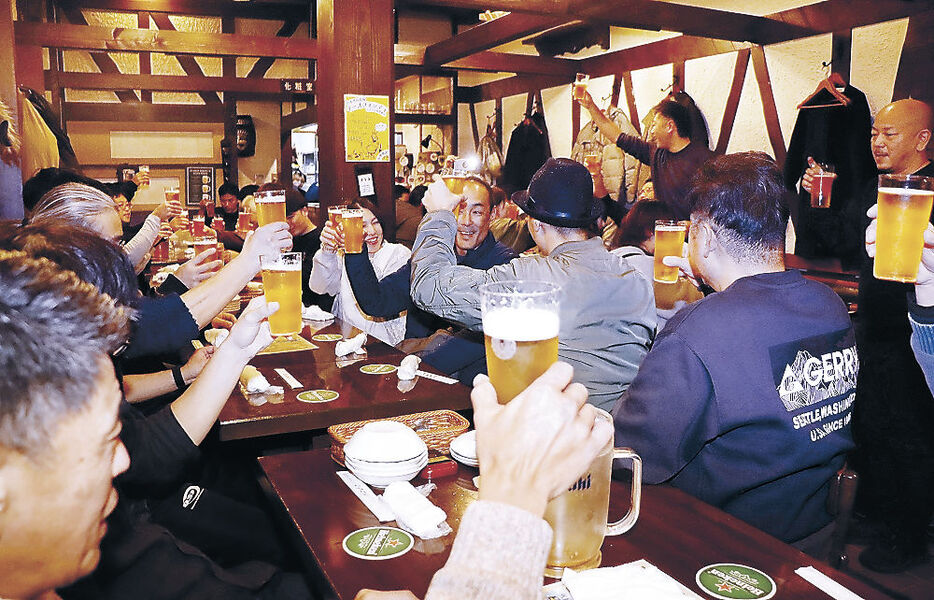 営業再開を祝して乾杯する常連客＝片町１丁目