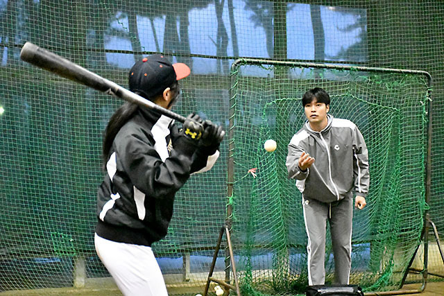 参加者を指導する石垣雅海内野手（右）＝酒田市光ケ丘野球場屋内練習場