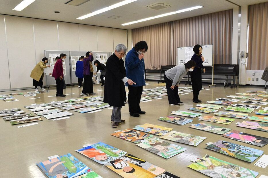 応募作品をじっくり見て審査する審査員（和歌山県田辺市秋津町で）