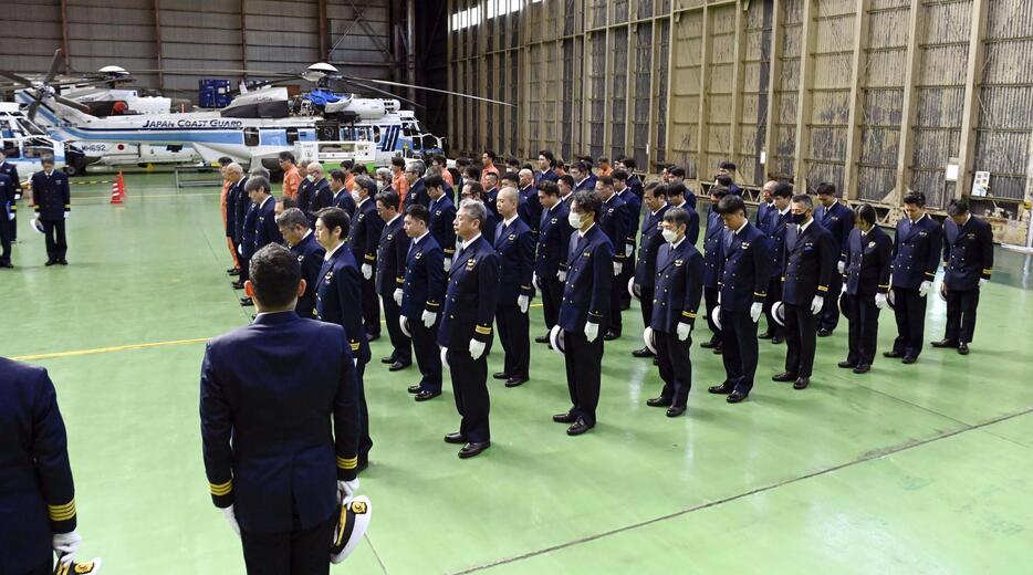 日航機との衝突事故により死亡した海上保安庁機の乗員5人の追悼式で、黙とうする参列者＝23日午前、第3管区海上保安本部羽田航空基地