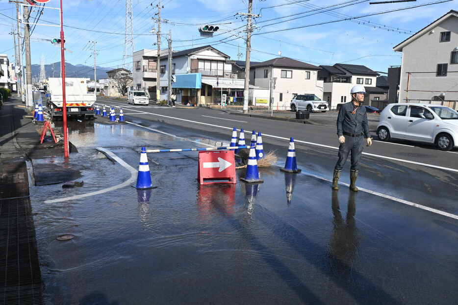 地下に埋設した水道管が破裂し水浸しになった県道周辺＝18日午前、静岡市清水区迎山町