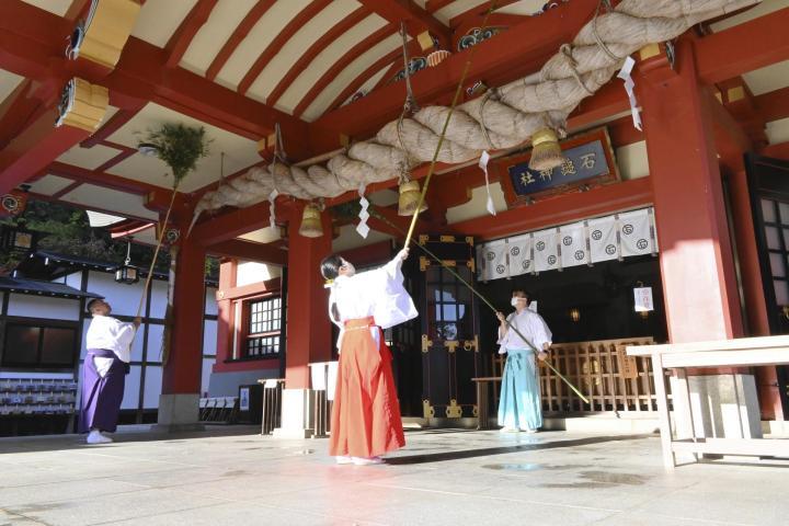 ササぼうきで本殿をきれいにする神社関係者＝13日午前9時10分ごろ、西条市西田