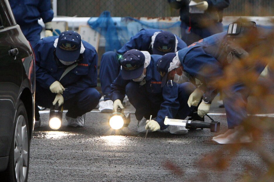 事件発生当初、大東さんが殺害された駐車場を調べる京都府警の捜査員ら（２０１３年１２月１９日、京都市山科区）