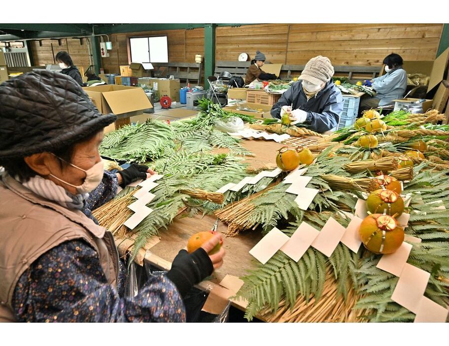 しめ縄に縁起物を飾り付ける女性たち（和歌山県田辺市中辺路町で）