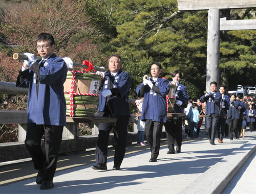 【しょうゆ樽を担いで宇治橋を進む参列者ら＝伊勢市の伊勢神宮内宮で】