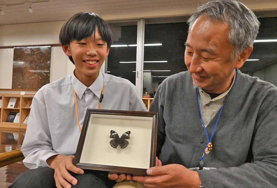 標本になったリュウキュウムラサキを岸本教授とともに手にする川合さん（左）＝静岡市駿河区のふじのくに地球環境史ミュージアム