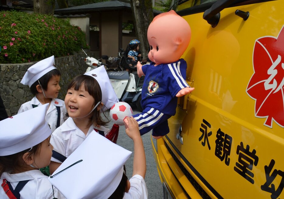 「サムライブルー」に衣替えしたキューピー人形の周りに集まる園児（２０１４年）