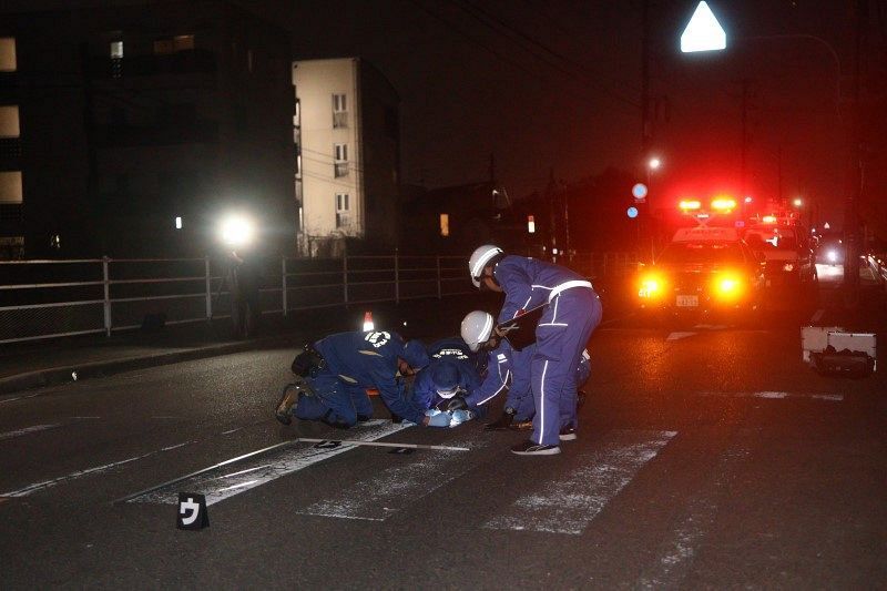 小学生がはねられた事故現場を調べる捜査員＝3日午後6時49分、岡山市北区法界院