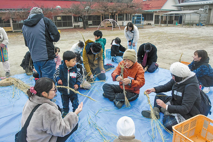 正月飾りをつくる親子ら