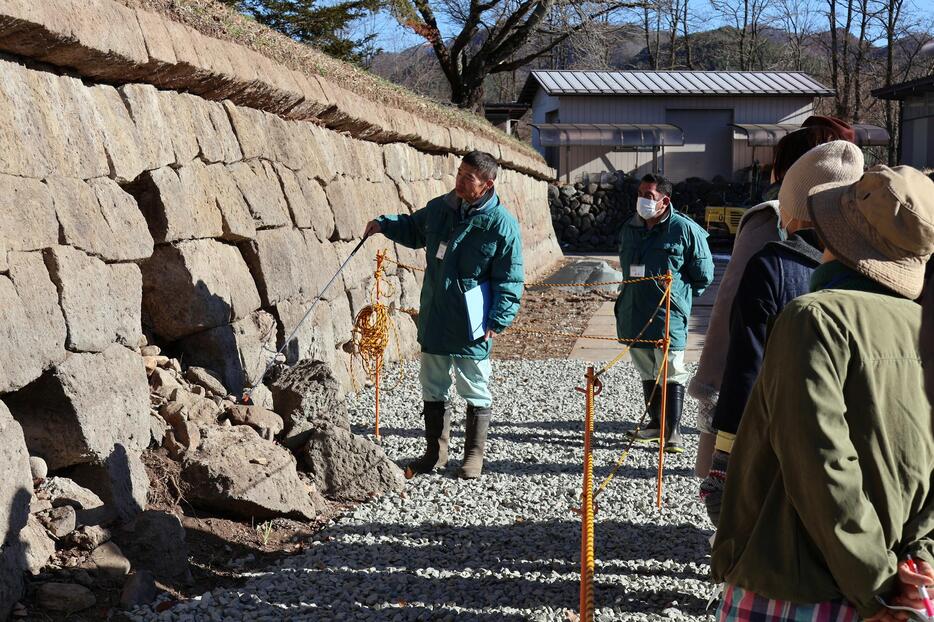 いつもは水の中…崩れていた石垣の説明を聞く参加者