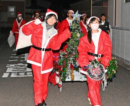 プレゼントの袋を背負い家々を回る中学生サンタ＝佐賀市の開成校区